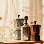 Moka pots, milk frother and cups inside a kitchen on a sunny afternoon in autumn